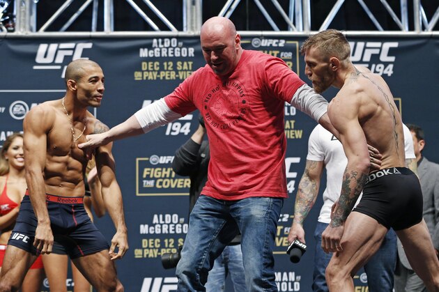 UFC president Dana White, center, stands between Conor McGregor, right, and Jose Aldo during the weigh-in for UFC 194 Friday, Dec. 11, 2015, in Las Vegas. McGregor and Aldo are scheduled to fight in a featherweight championship bout Saturday in Las Vegas. (AP Photo/John Locher)
