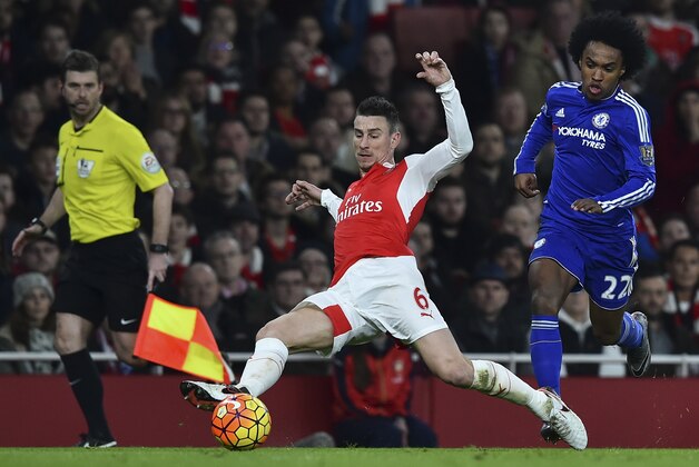Arsenal's French defender Laurent Koscielny (C) stretches for the ball during the English Premier League football match between Arsenal and Chelsea at the Emirates Stadium in London on January 24, 2016. AFP PHOTO / BEN STANSALL

RESTRICTED TO EDITORIAL USE. No use with unauthorized audio, video, data, fixture lists, club/league logos or 'live' services. Online in-match use limited to 75 images, no video emulation. No use in betting, games or single club/league/player publications. / AFP / BEN STANSALL        (Photo credit should read BEN STANSALL/AFP/Getty Images)