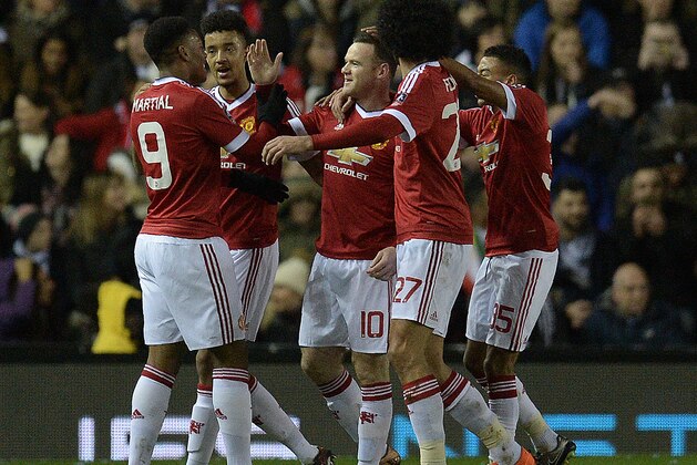 Manchester United's French striker Anthony Martial (L) congratulates Manchester United's English striker Wayne Rooney (C) for scoring his team's first goal during the FA cup fourth round football match between Derby County and Manchester United at Pride Park stadium in Derby on January 29, 2016.
Manchester United won the match 3-1. / AFP / OLI SCARFF / RESTRICTED TO EDITORIAL USE. No use with unauthorized audio, video, data, fixture lists, club/league logos or 'live' services. Online in-match use limited to 75 images, no video emulation. No use in betting, games or single club/league/player publications.  /         (Photo credit should read OLI SCARFF/AFP/Getty Images)