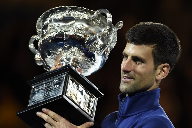 Novak Djokovic of Serbia holds his trophy aloft after defeating Andy Murray of Britain in the men's singles final at the Australian Open tennis championships in Melbourne, Australia, Sunday, Jan. 31, 2016.(AP Photo/Andrew Brownbill)