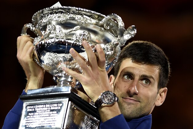 Novak Djokovic of Serbia holds his trophy aloft after defeating Andy Murray of Britain in the men's singles final at the Australian Open tennis championships in Melbourne, Australia, Sunday, Jan. 31, 2016.(AP Photo/Andrew Brownbill)