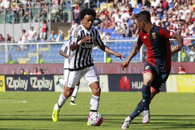 Juventus' Juan Cuadrado, left, faces Genoa’s Armando Izzo during a Serie A soccer match between Genoa and Juventus, in Genoa's Luigi Ferraris stadium Italy, Sunday, Sept. 20, 2015. (AP Photo/Tano Pecoraro)