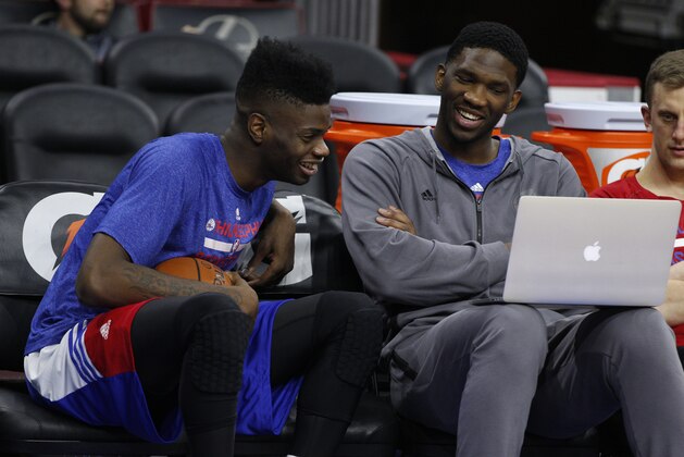 Philadelphia 76ers' Joel Embiid, right, of Cameroon and Nerlens Noel, left, share a laugh while looking at a laptop during warm-ups prior to the first half of an NBA basketball game against the Brooklyn Nets, Wednesday, Nov. 26, 2014, in Philadelphia. (AP Photo/Chris Szagola)