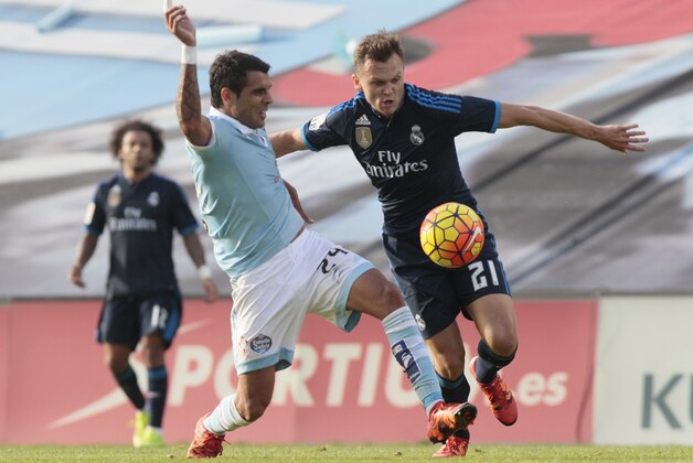 Real Madrid’s Denis Cheryshev, left, fights for the ball with RC Celta’s Augusto Fernandez during a Spanish La Liga soccer match between RC Celta and Real Madrid, at the Balaidos stadium in Vigo, Spain, Saturday, Oct. 24, 2015. (AP Photo/Lalo R. Villar)