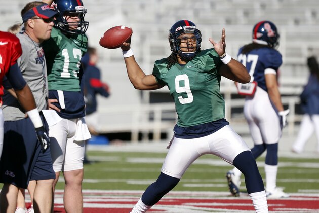 Mississippi football coach Hugh Freeze, left, watches quarterback Maikhail Miller (9) pass as he preps quarterback Robert Ratliff (13) during NCAA college football practice on Friday, April 5, 2013, in Oxford, Miss. The Rebels are to have their full scrimmage on Saturday morning at Vaught-Hemingway Stadium. (AP Photo/Rogelio V. Solis)