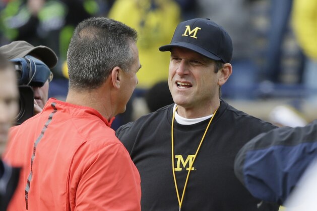 Ohio State head coach Urban Meyer, left, meets with Michigan head coach Jim Harbaugh before the first half of an NCAA college football game, Saturday, Nov. 28, 2015, in Ann Arbor, Mich. (AP Photo/Carlos Osorio)