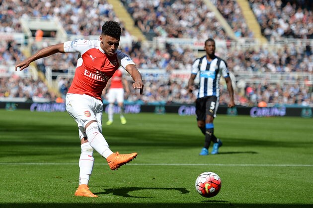 Arsenal's English midfielder Alex Oxlade-Chamberlain takes the shot which deflects off Newcastle United's Argentinian defender Fabricio Coloccini (not pictured) for Arsenal's opening goal in the English Premier League football match between Newcastle United and Arsenal at St James' Park in Newcastle-upon-Tyne, north east England, on August 29, 2015. AFP PHOTO / OLI SCARFF  RESTRICTED TO EDITORIAL USE. No use with unauthorized audio, video, data, fixture lists, club/league logos or 'live' services. Online in-match use limited to 75 images, no video emulation. No use in betting, games or single club/league/player publications.        (Photo credit should read OLI SCARFF/AFP/Getty Images)