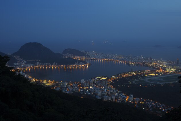 This Nov. 10, 2015 photo, shows an evening view of the Rodrigo de Freitas Lagoon in Rio de Janeiro, Brazil. The Associated Press' reports on water contamination in Rio were initially based on samples taken along the shores of the lagoon where the 2016 Olympics’ rowing and canoeing events will be held.  (AP Photo/Leo Correa)