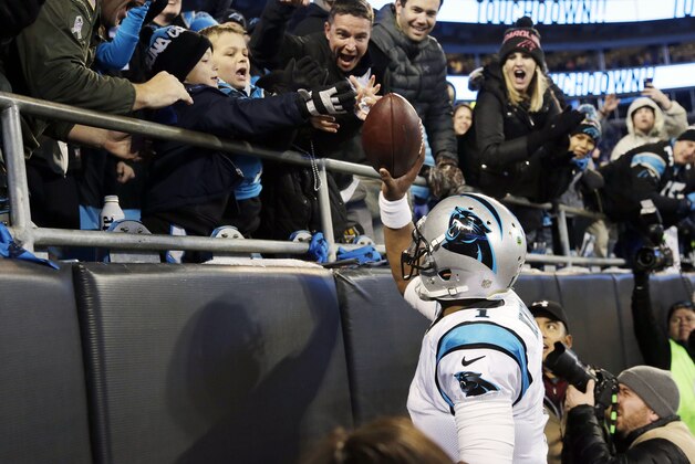 Carolina Panthers' Cam Newton gives a ball to a fan after a touchdown during the first half the NFL football NFC Championship game against the Arizona Cardinals, Sunday, Jan. 24, 2016, in Charlotte, N.C. (AP Photo/Bob Leverone)