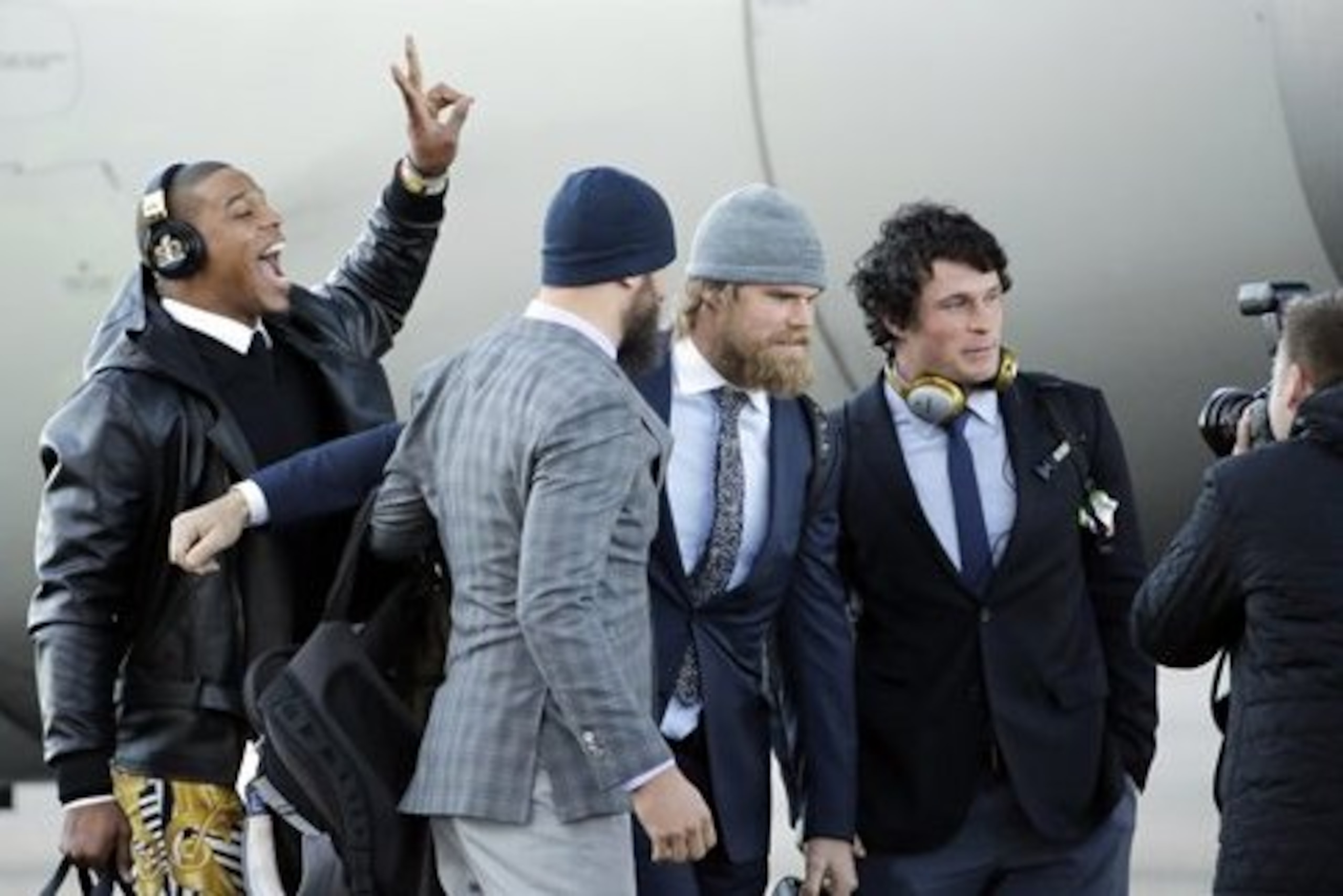 Carolina Panthers' Cam Newton jumps into a picture being taken of Luke Kuechly, right to left, Greg Olsen and Derek Anderson after getting off the plane at the Mineta San Jose International Airport as they arrive for the NFL Super Bowl football game Sunday, Jan. 31, 2016, in San Jose, Calif.  The Panthers play the Denver Broncos on Sunday, Feb. 7, 2015, in Super Bowl 50. (AP Photo/David J. Phillip)