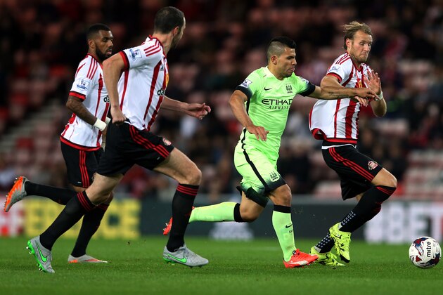 Manchester City's Sergio Aguero, second right, vies for the ball with Sunderland's Ola Toivonen, right, and captain John O'Shea, left, during the English League Cup third round soccer match between Sunderland and Manchester City at the Stadium of Light, Sunderland, England, Tuesday, Sept. 22, 2015 (AP Photo/Scott Heppell)