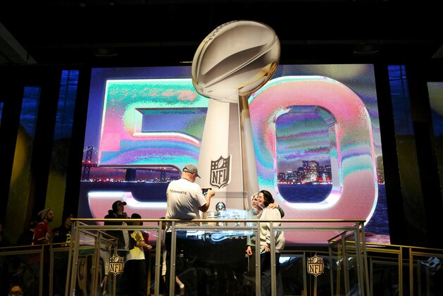 NFL fans pose for a photo with the Lombardi Trophy at an exhibit at NFLX on Sunday, January 31, 2106 in San Francisco, CA. (Gregory Payan/AP Images for NFL)