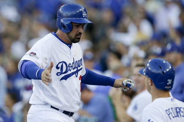 Los Angeles Dodgers' Adrian Gonzalez, left, is greeted by teammate Yasmani Grandal (9), right, after scoring off a single by Andre Ethier in Game 5 of baseball's National League Division Series against the New York Mets  Thursday, Oct. 15, 2015, in Los Angeles. (AP Photo/Alex Gallardo)