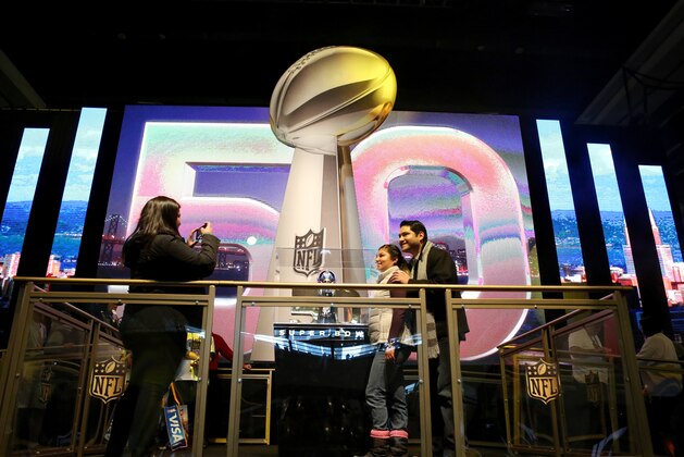 NFL fans pose for a photo with the Lombardi Trophy at an exhibit at NFLX on Sunday, January 31, 2106 in San Francisco, CA. (Gregory Payan/AP Images for NFL)