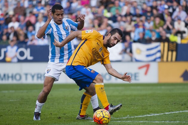 FC Barcelona's Arda Turan, right, duels for the ball against Malaga's Roberto Jose Rosales, left,  during a Spanish La Liga soccer match between Malaga and Barcelona at La Rosaleda stadium in Malaga, Spain, Saturday, Jan. 23, 2016. (AP Photo/Daniel Tejedor)