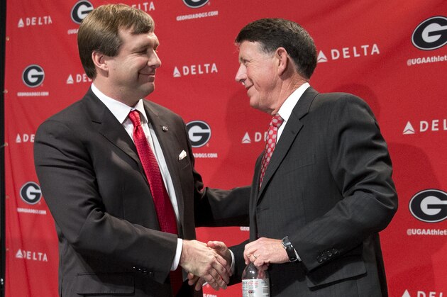 Alabama defensive coordinator Kirby Smart, left, speaks to Georgia athletic director Greg Mcgarity after during a press conference where he was introduced as Georgia's new head football coach  Monday, Dec. 7, 2015, in Athens, Ga. Smart will stay with the Crimson Tide through the NCAA college playoffs. (AP Photo/John Bazemore)