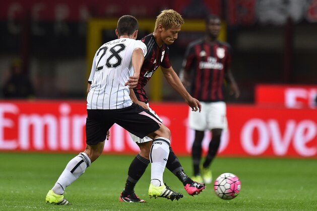 MILAN, ITALY - SEPTEMBER 19:  Keisuke Honda (L) of Milan and Mato Jajalo of Palermo compete for the ball during the Serie A match between AC Milan and US Citta di Palermo at Stadio Giuseppe Meazza on September 19, 2015 in Milan, Italy.  (Photo by Tullio M. Puglia/Getty Images)