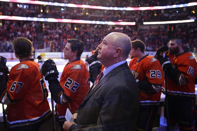 Anaheim Ducks head coach Bruce Boudreau, center, listens to the national anthem before an NHL hockey game with the Nashville Predators, Sunday, Nov. 1, 2015, in Anaheim, Calif. (AP Photo/Jae C. Hong)