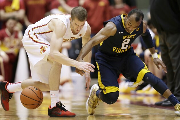 Iowa State guard Matt Thomas, left, fights for a loose ball with West Virginia guard Jevon Carter, right, during the first half of an NCAA college basketball game Tuesday, Feb. 2, 2016, in Ames, Iowa. (AP Photo/Charlie Neibergall)