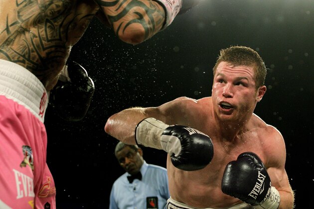 Saul 'Canelo' Alvarez of  Mexico (R) measures Miguel Cotto of Puerto Rico (L) during their middleweight championship boxing match on November 21, 2015 at the Mandalay Bay Events Center in Las Vegas, Nevada.  Alvarez captured the vacant World Boxing Council middleweight title with a unanimous decision victory over Cotto.    AFP PHOTO / JOHN GURZINSKI        (Photo credit should read JOHN GURZINSKI/AFP/Getty Images)