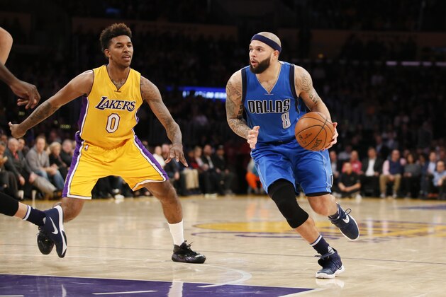 Dallas Mavericks' Deron Williams, right, dribbles the ball while Los Angeles Lakers' Nick Young, left, defends him during the first half of an NBA basketball game, Tuesday, Jan. 26, 2016, in Los Angeles. (AP Photo/Danny Moloshok)