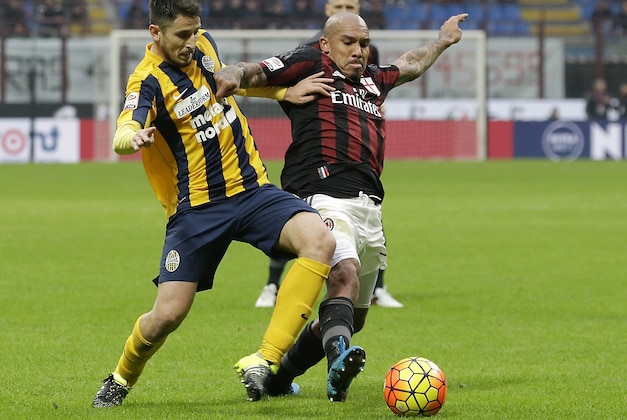 AC Milan's Nigel de Jong, right, challenges for the ball with Verona’s Federico Viviani during the Serie A soccer match between AC Milan and Hellas Verona at the San Siro stadium in Milan, Italy, Sunday, Dec. 13 , 2015. (AP Photo/Antonio Calanni)