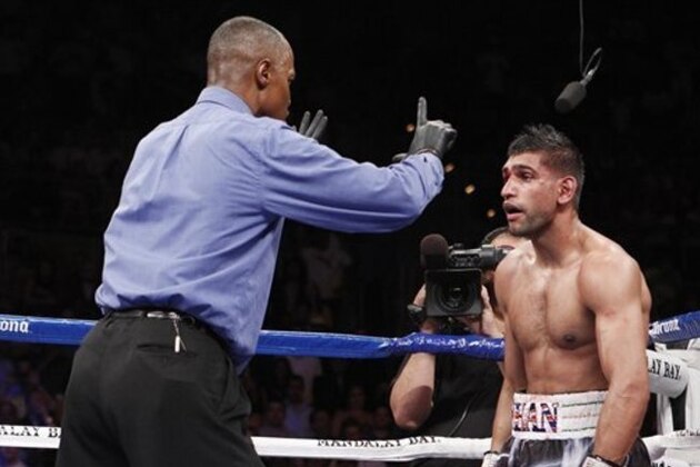 Amir Khan, of England, is counted to by referee Kenny Bayless, left, after being knocked down by Danny Garcia, of the United States, during their WBC and WBA junior welterweight title boxing match, Saturday, July 14, 2012, in Las Vegas. Garcia won by a fourth round TKO victory. (AP Photo/Eric Jamison)