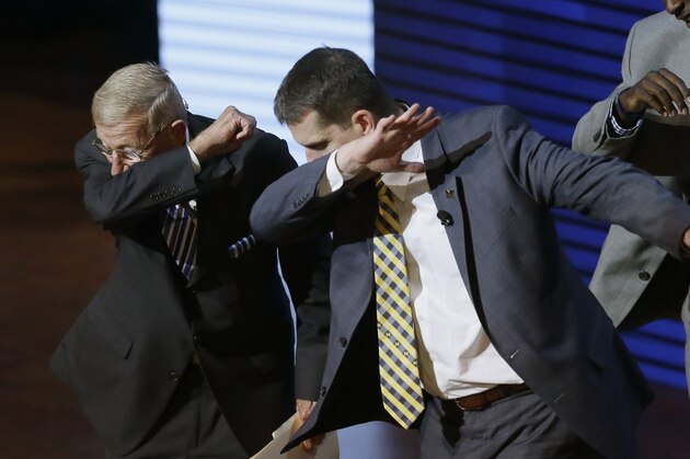Former coach Lou Holtz, left, and University of Michigan football coach Jim Harbaugh perform a dab during the Signing With the Stars spectacle, Wednesday, Feb. 3, 2016 in Ann Arbor, Mich. Guests and superstars appeared on stage to welcome the University of Michigan's new recruits on National Signing Day.  (AP Photo/Carlos Osorio)