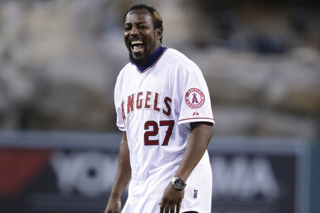 Vladimir Guerrero laughs after throwing the ceremonial first pitch before an opening day baseball game between the Los Angeles Angels and the Seattle Mariners on Monday, March 31, 2014, in Anaheim, Calif. Guerrero signed a one-day contract to retire with the Los Angeles Angels on Monday. (AP Photo/Jae C. Hong)