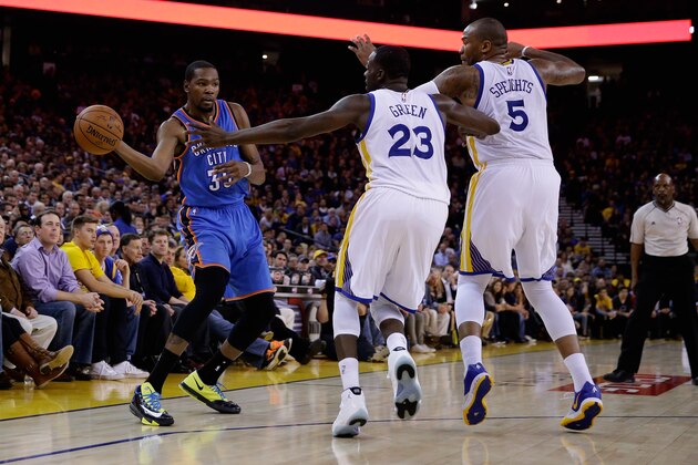 OAKLAND, CA - DECEMBER 18:  Kevin Durant #35 of the Oklahoma City Thunder passes the ball around Draymond Green #23 and Marreese Speights #5 of the Golden State Warriors at ORACLE Arena on December 18, 2014 in Oakland, California. NOTE TO USER: User expressly acknowledges and agrees that, by downloading and or using this photograph, User is consenting to the terms and conditions of the Getty Images License Agreement.  (Photo by Ezra Shaw/Getty Images)