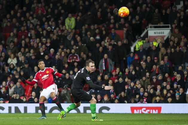 Manchester United's Anthony Martial, left, scores past Stoke's Glenn Whelan during the English Premier League soccer match between Manchester United and Stoke at Old Trafford Stadium, Manchester, England, Tuesday, Feb. 2, 2016. (AP Photo/Jon Super)
