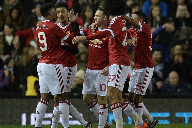 Manchester United's French striker Anthony Martial (L) congratulates Manchester United's English striker Wayne Rooney (C) for scoring his team's first goal during the FA cup fourth round football match between Derby County and Manchester United at Pride Park stadium in Derby on January 29, 2016.
Manchester United won the match 3-1. / AFP / OLI SCARFF / RESTRICTED TO EDITORIAL USE. No use with unauthorized audio, video, data, fixture lists, club/league logos or 'live' services. Online in-match use limited to 75 images, no video emulation. No use in betting, games or single club/league/player publications.  /         (Photo credit should read OLI SCARFF/AFP/Getty Images)