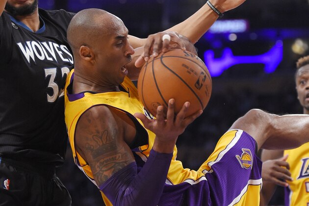 Los Angeles Lakers forward Kobe Bryant, center, comes down with a rebound while under pressure from Minnesota Timberwolves center Karl-Anthony Towns, left, and forward Julius Randle watches during the second half of an NBA basketball game, Tuesday, Feb. 2, 2016, in Los Angeles. The Lakers won 119-115. (AP Photo/Mark J. Terrill)