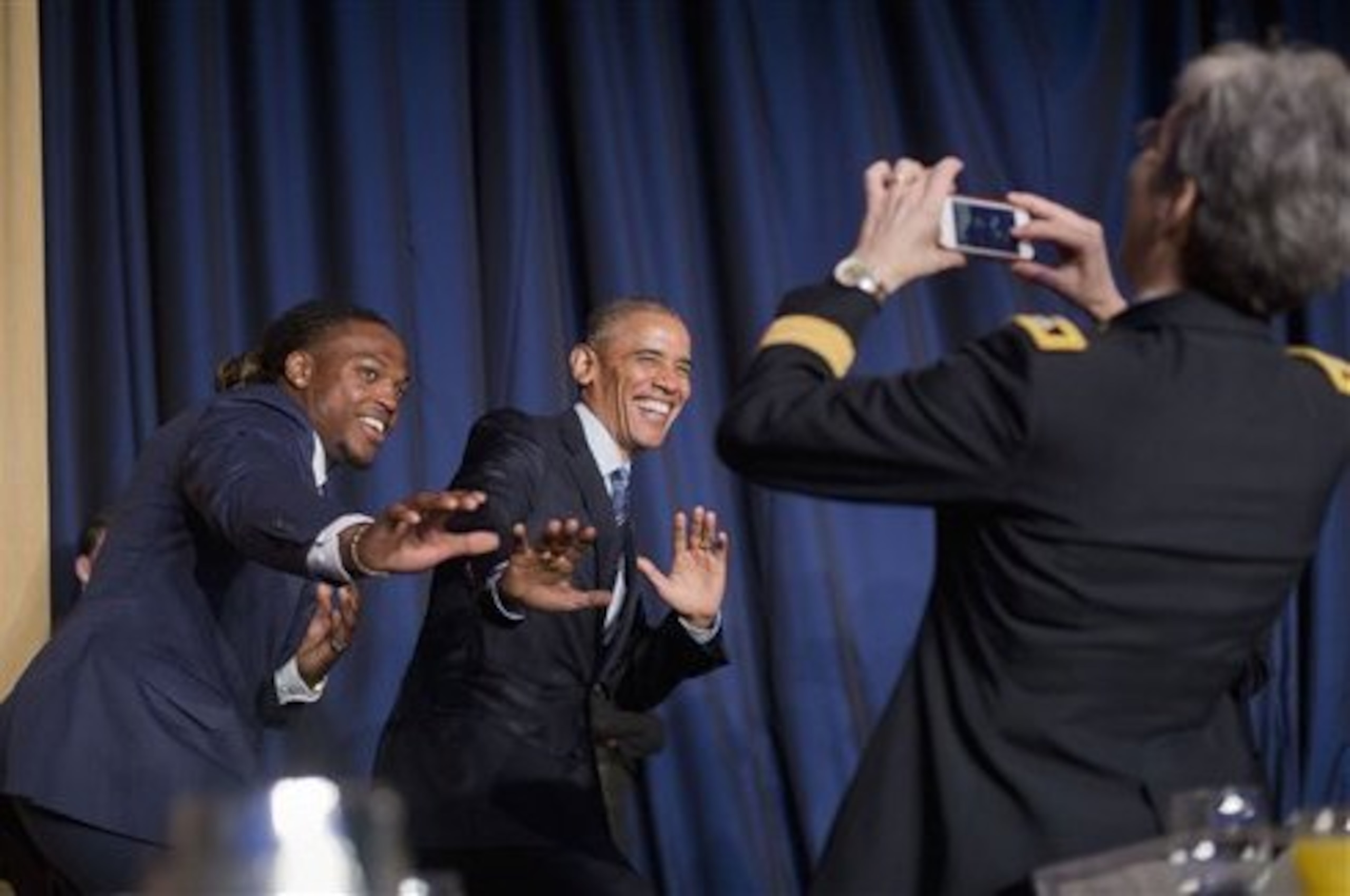 Army Maj. Gen. Julie A. Bentz photographs President Barack Obama and University of Alabama football player and Heisman Trophy winner Derrick Henry as they strike a 'Heisman-pose' for a photo during the National Prayer Breakfast in Washington, Thursday, Feb. 4, 2016. The annual event brings together U.S. and international leaders from different parties and religions for an hour devoted to faith. (AP Photo/Pablo Martinez Monsivais)