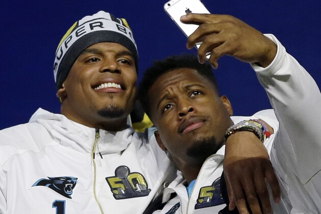 FILE - In this Monday, Feb. 1 2016, file photo, Carolina Panthers' Jonathan Stewart takes a selfie with Cam Newton during Opening Night for the NFL Super Bowl 50 football game in San Jose, Calif. Whether it is Newton photobombing his teammates getting off  the plane at the Super Bowl, Mike Tolbert playing deejay in the team's locker room or teammates attending Star Wars movies together, the Panthers have, and continue to be, a loose, tight-knit bunch entering Super Bowl week. (AP Photo/David J. Phillip, File)
