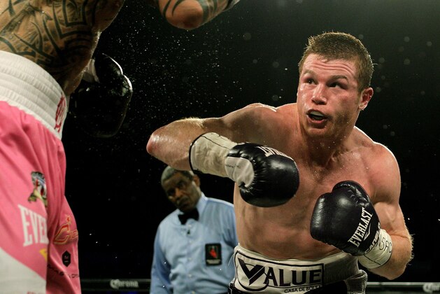 Saul 'Canelo' Alvarez of  Mexico (R) measures Miguel Cotto of Puerto Rico (L) during their middleweight championship boxing match on November 21, 2015 at the Mandalay Bay Events Center in Las Vegas, Nevada.  Alvarez captured the vacant World Boxing Council middleweight title with a unanimous decision victory over Cotto.    AFP PHOTO / JOHN GURZINSKI        (Photo credit should read JOHN GURZINSKI/AFP/Getty Images)