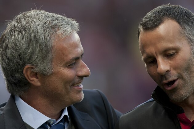 Chelsea's manager Jose Mourinho, left, speaks to Manchester United's Ryan Giggs as they make their way down the touchline before their English Premier League soccer match at Old Trafford Stadium, Manchester, England, Monday Aug. 26, 2013. (AP Photo/Jon Super)