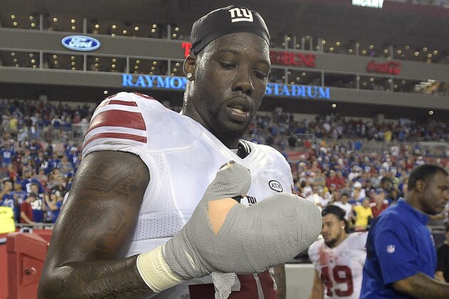 New York Giants defensive end Jason Pierre-Paul removes the bandage from his damaged hand after the Giants defeated the Tampa Bay Buccaneers 32-18 during an NFL football game Sunday, Nov. 8, 2015, in Tampa, Fla. (AP Photo/Phelan M. Ebenhack)