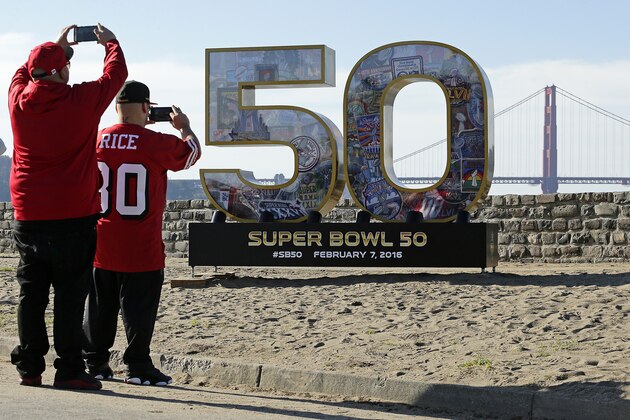 People take photos of a Super Bowl 50 sign at the beach near the Golden Gate Bridge Friday, Feb. 5, 2016, in San Francisco. (AP Photo/Charlie Riedel)