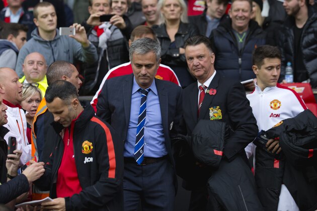 Chelsea's manager Jose Mourinho, center left, makes his way from the opposition dugout after greeting Manchester United manager Louis van Gaal, centre right, during their English Premier League soccer match between Manchester United and Chelsea at Old Trafford Stadium, Manchester, England, Sunday Oct. 26, 2014. (AP Photo/Jon Super)