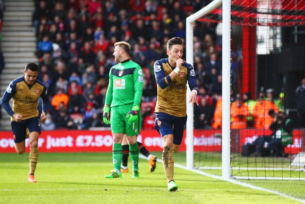 BOURNEMOUTH, ENGLAND - FEBRUARY 07:  Goalkeeper Artur Boruc of Bournemouth looks dejected as Mesut Ozil of Arsenal celebrates as he scores their first goal during the Barclays Premier League match between A.F.C. Bournemouth and Arsenal at the Vitality Stadium on February 7, 2016 in Bournemouth, England.  (Photo by Matthew Lewis/Getty Images)