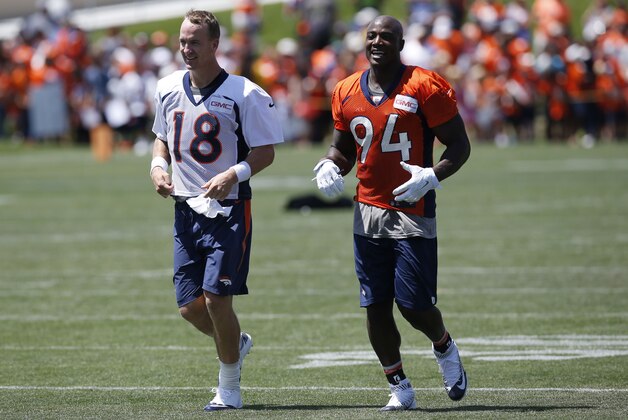 Denver Broncos quarterback Peyton Manning (18) and Denver Broncos defensive end DeMarcus Ware (94) run in from practice at the team's NFL football training camp Friday, July 31, 2015, in Englewood, Colo. (AP Photo/David Zalubowski)