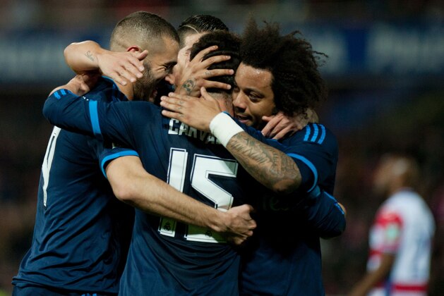 Real Madrid's French forward Karim Benzema (L) celebrates a goal with teammates during the Spanish league football match Granada FC vs Real Madrid CF at Nuevo Los Carmenes stadium in Granada on February 7, 2016.   AFP PHOTO / JORGE GUERRERO / AFP / Jorge Guerrero        (Photo credit should read JORGE GUERRERO/AFP/Getty Images)