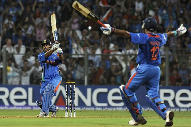 Indian captain Mahendra Singh Dhoni (L) hits a six to win against Sri Lanka as teammate Yuvraj Singh reacts during the Cricket World Cup 2011 final at The Wankhede Stadium in Mumbai on April 2, 2011. India beat Sri Lanka by six wickets. AFP PHOTO/Indranil MUKHERJEE (Photo credit should read INDRANIL MUKHERJEE/AFP/Getty Images)