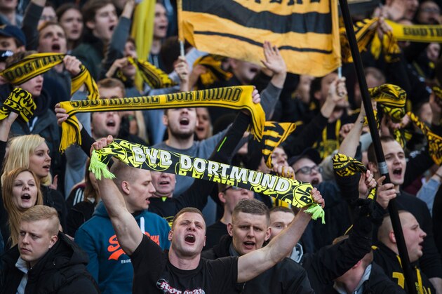 Dortmund fans during cheer during the German first division Bundesliga football match, Hertha Berlin v Borussia Dortmund, at the Olympic stadium in Berlin on February 6, 2016.  / AFP / ODD ANDERSEN / RESTRICTIONS: DURING MATCH TIME: DFL RULES TO LIMIT THE ONLINE USAGE TO 15 PICTURES PER MATCH AND FORBID IMAGE SEQUENCES TO SIMULATE VIDEO. == RESTRICTED TO EDITORIAL USE == FOR FURTHER QUERIES PLEASE CONTACT DFL DIRECTLY AT + 49 69 650050
        (Photo credit should read ODD ANDERSEN/AFP/Getty Images)