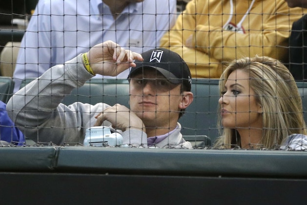 In this file photo made Tuesday, April 14, 2015, Johnny Manziel, left, sits with  Colleen Crowley during a baseball game between the Los Angeles Angels and the Texas Rangers in Arlington, Texas. Dallas police announced Friday, Feb. 5, 2016,  they were launching a criminal investigation into a domestic violence assault complaint filed against Manziel, who was involved in an altercation last weekend during which he allegedly struck his ex-girlfriend, Colleen Crowley, several times. (AP Photo/LM Otero)