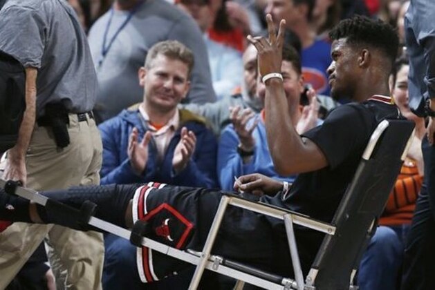 Chicago Bulls guard Jimmy Butler waves to fans as they applaud him while Butler is taken off the court after being injured late in the first half of his team's NBA basketball game against the Denver Nuggets on Friday, Feb. 5, 2016, in Denver. (AP Photo/David Zalubowski)