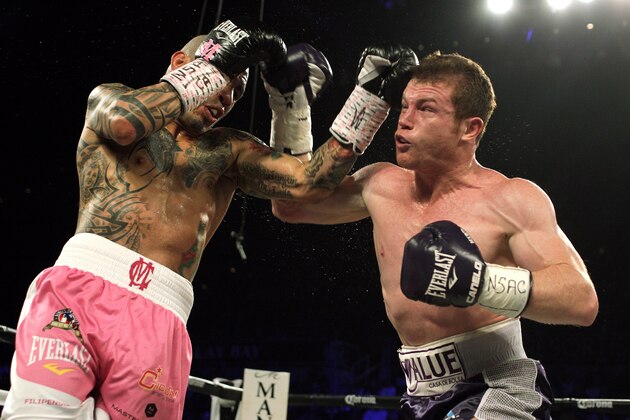 Miguel Cotto of Puerto Rico (L) defends against Saul 'Canelo' Alvarez of  Mexico (R) during their middleweight championship boxing match on November 21, 2015 at the Mandalay Bay Events Center in Las Vegas, Nevada.  Alvarez captured the vacant World Boxing Council middleweight title with a unanimous decision victory over Cotto.    AFP PHOTO / JOHN GURZINSKI        (Photo credit should read JOHN GURZINSKI/AFP/Getty Images)