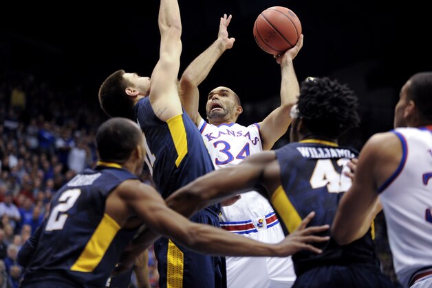 LAWRENCE, KS - FEBRUARY 9:  Perry Ellis #34 of the Kansas Jayhawks shoots against Nathan Adrian #11, Jevon Carter #2 and Devin Williams #41 of the West Virginia Mountaineers in the first half at Allen Fieldhouse on February 9, 2015 in Lawrence, Kansas. (Photo by Ed Zurga/Getty Images)