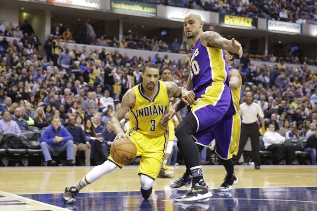 Indiana Pacers guard George Hill (3) cuts under Los Angeles Lakers center Robert Sacre (50) during the second half of an NBA basketball game in Indianapolis, Monday, Feb. 8, 2016. The Pacers defeated the Lakers 89-87. (AP Photo/Michael Conroy)